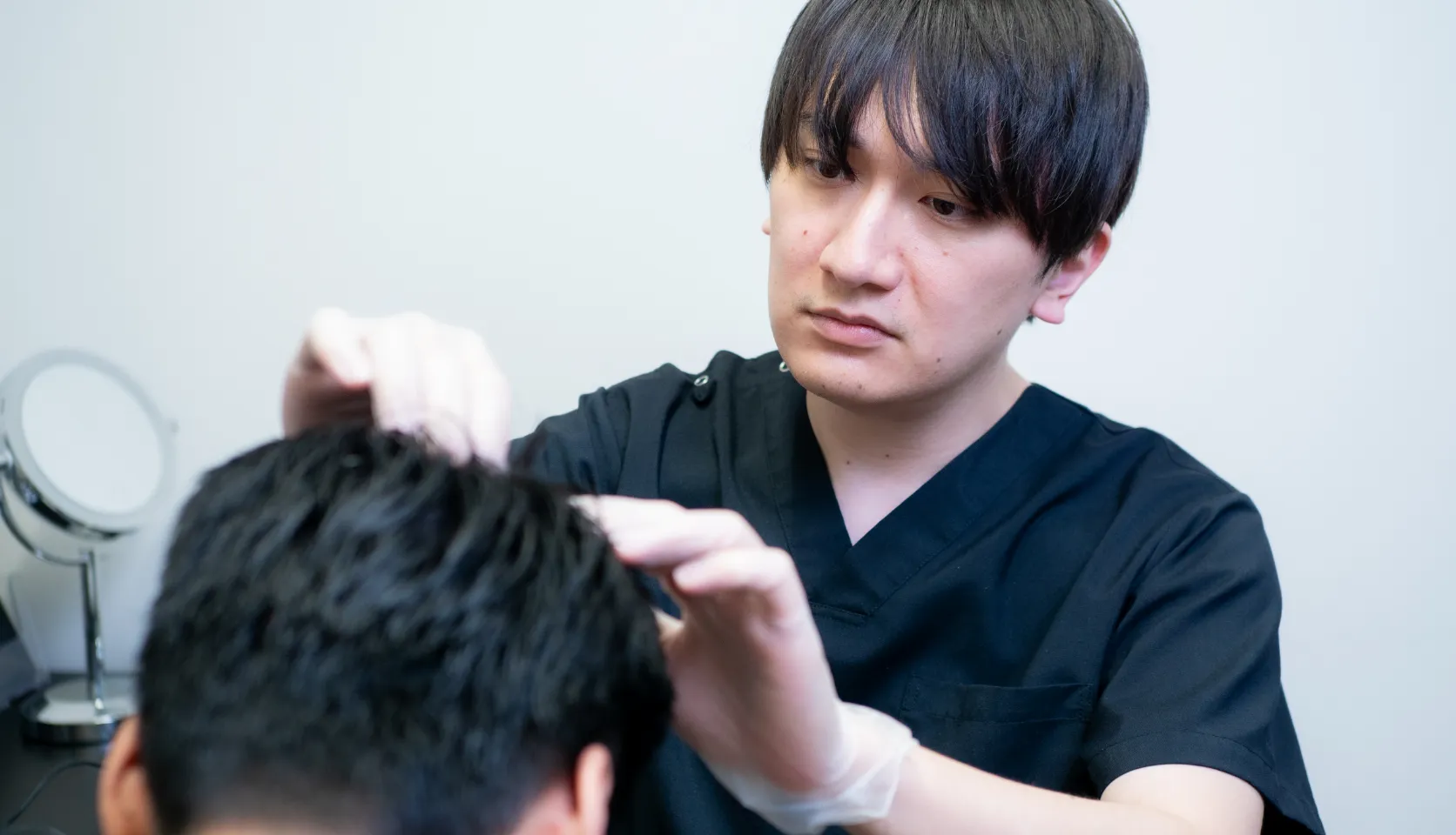 患者の初期脱毛の症状を確認する医師の様子