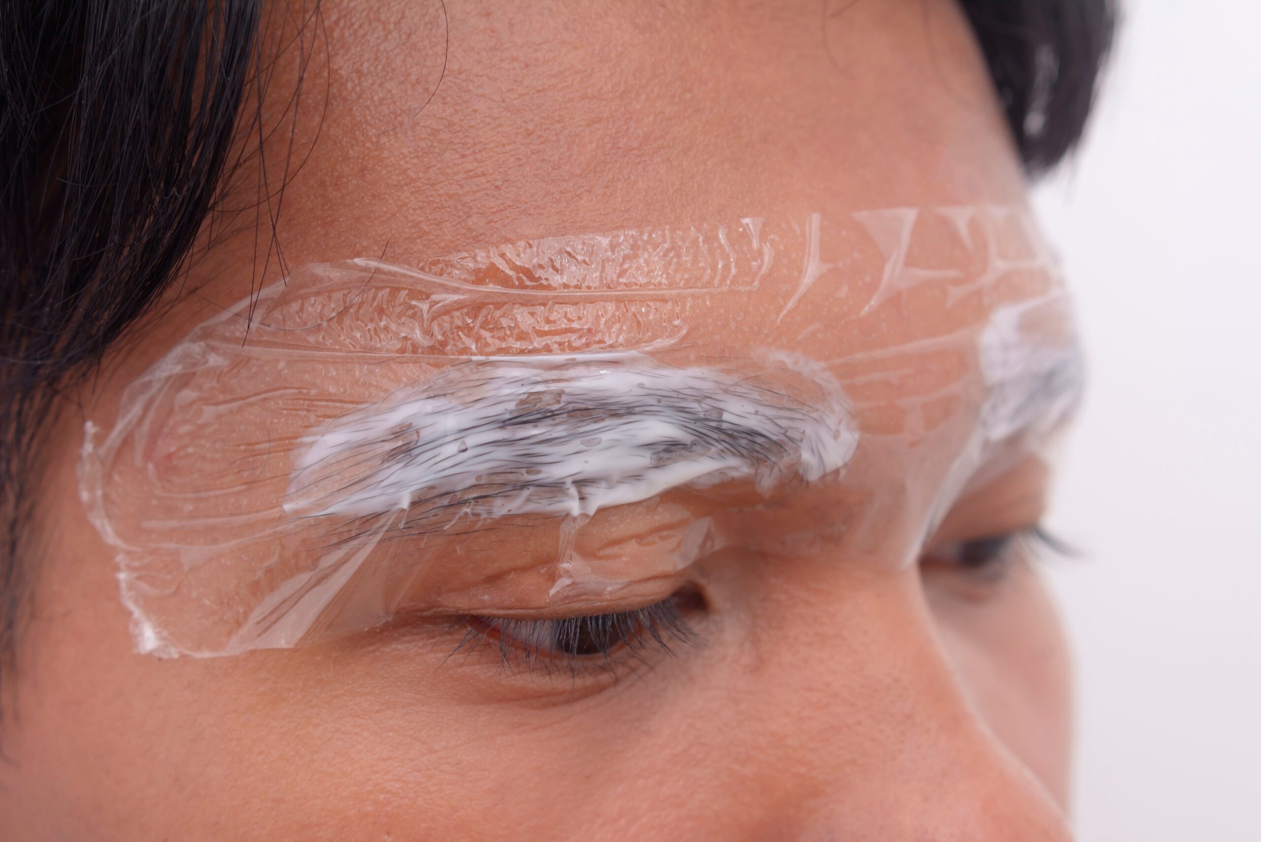 Close-up,Of,A,Man’s,Eyebrows,With,Numbing,Cream,Wrapped,In