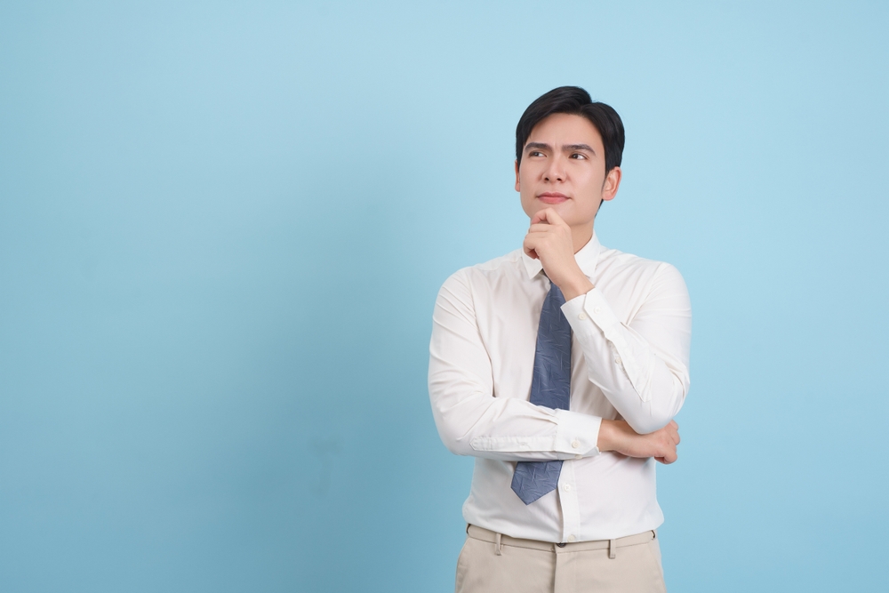 A,Man,Dressed,In,A,White,Shirt,And,Tie,Stands